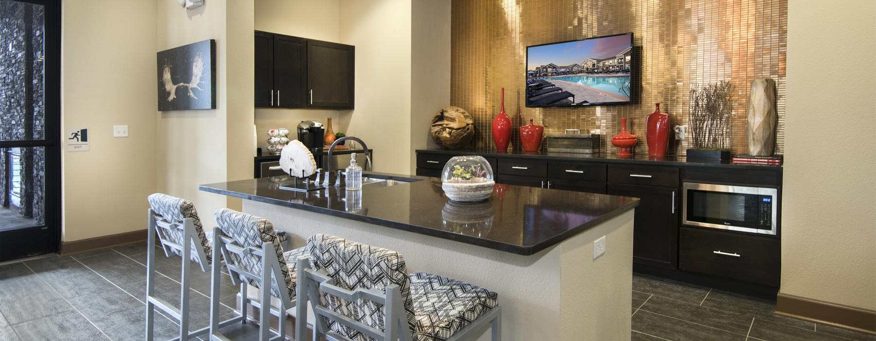a kitchen with a bar and chairs